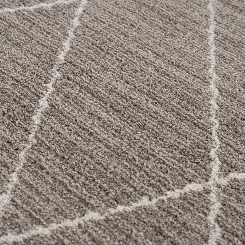Close-up of the Kami Area Rug, showing its dark beige texture and ivory geometric Moroccan pattern. Texture