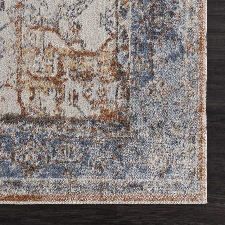 Close-up of the Blue Orange Hera Washable rug, showing its traditional vintage pattern and texture on a dark wood floor. Swatch