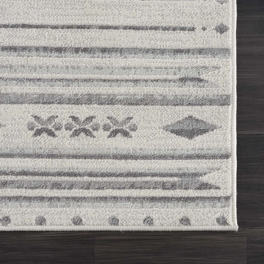 Close-up of Tigri Aztec Ivory & Gray rug showing farmhouse style pattern and texture on dark wood floor. Corner