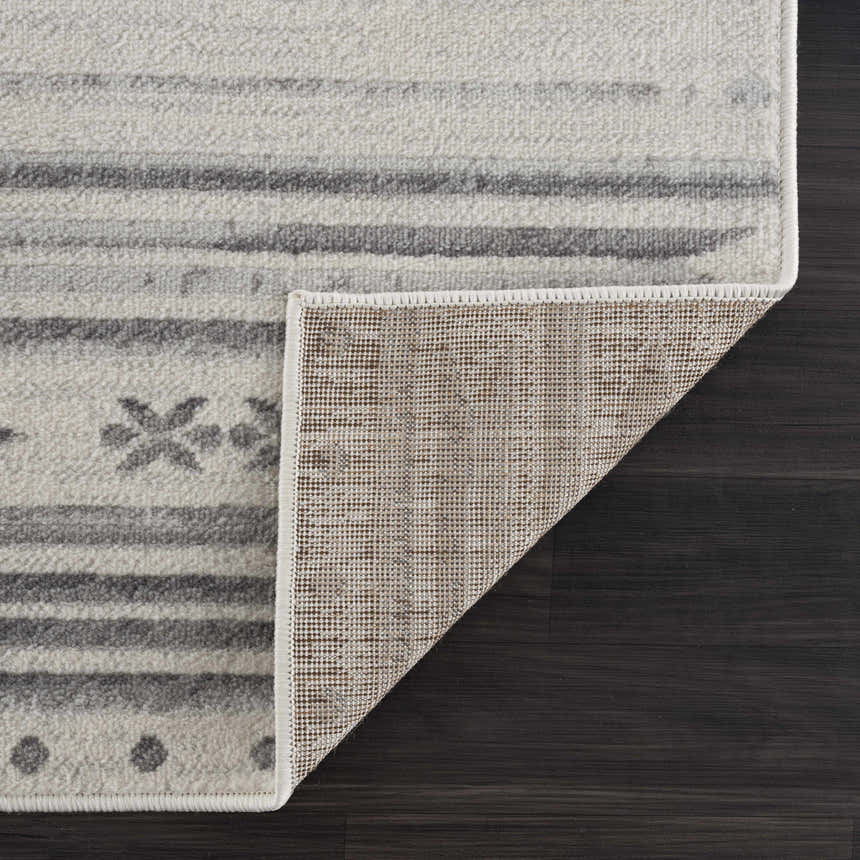 Close-up of Tigri Aztec Ivory & Gray rug showing the gray stripes, aztec pattern, ivory background, and rug backing. Fold