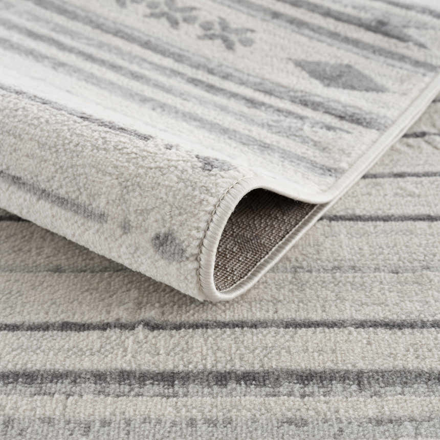 Close-up of Tigri Aztec Ivory & Gray rug showing the soft texture, gray stripes, and Aztec-inspired geometric pattern. Fold