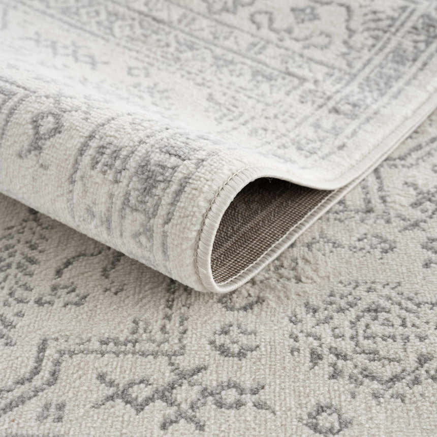 Close-up of the Tigried Ivory & Gray 2323 Area Rug showing its soft texture and bohemian-inspired gray pattern on an ivory base. Fold