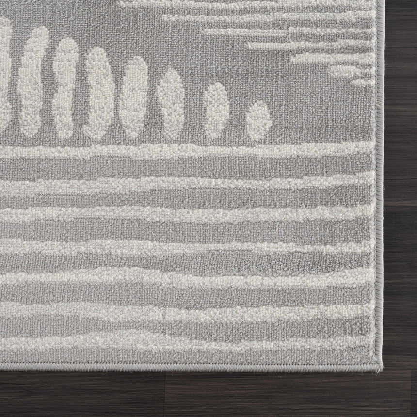 Close-up of the Tigrisis 2326 Gray Rug with a textured gray and ivory Moroccan-inspired pattern on a dark wood floor. Corner