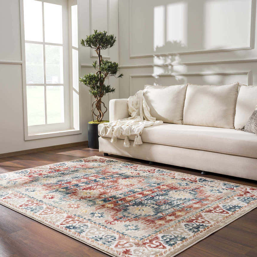 Living room scene with Bindi Blue & Rose Area Rug, beige sofa, wood floors, and bright natural light. Southwestern style. Roomscene-Rectangle