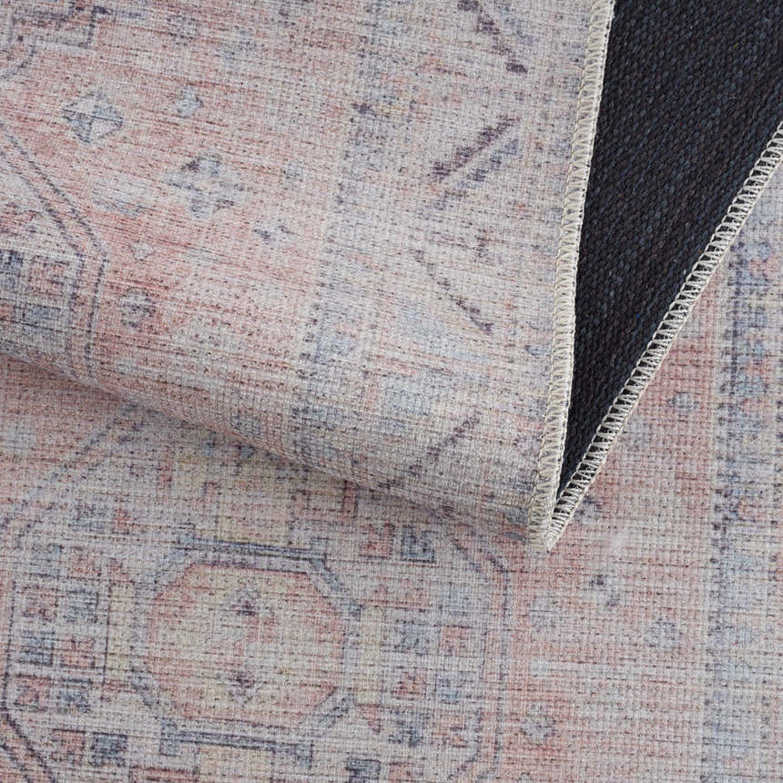 Close-up of the Morcott Peach Washable Area Rug showing its chenille texture and traditional black, ivory, and peach pattern. Fold