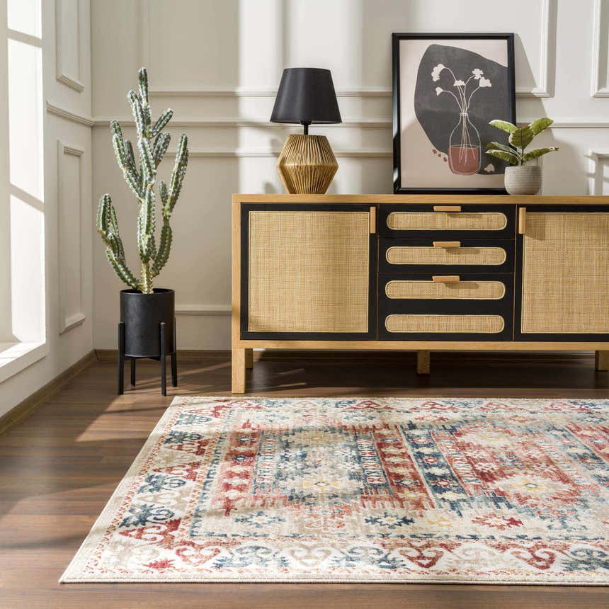 Living room scene with Bindi Blue & Rose Area Rug, wood floors, and a rattan cabinet with black accents. Roomscene-Rectangle