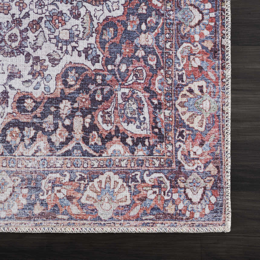Close-up of the Red Cael Tumble Dry Washable Rug. Features a vintage Persian pattern in red, navy, and off-white on dark wood floor. Swatch