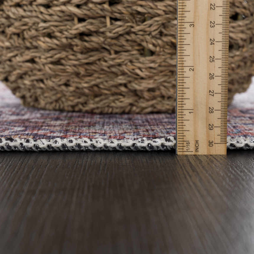 Close-up of the Red Cael Tumble Dry Washable Rug showing the pile height and woven edge detail with a ruler for scale. Pile