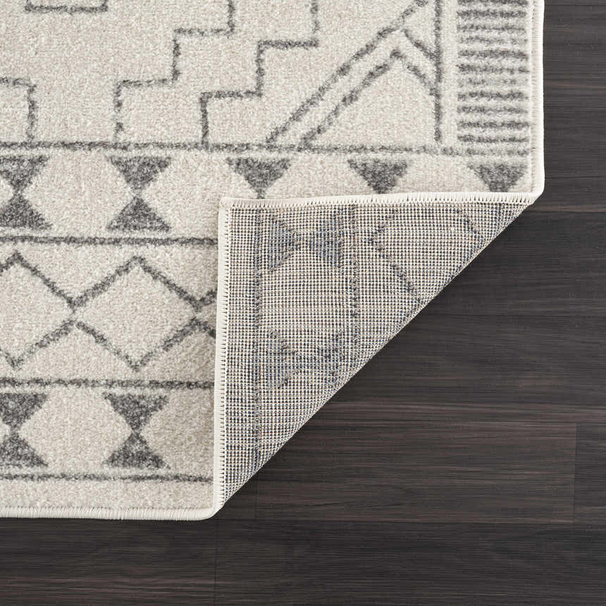 Close-up of KMRSH-4614 Ivory Tribal Carpet showing gray geometric pattern and polypropylene texture on dark wood floor. Fold