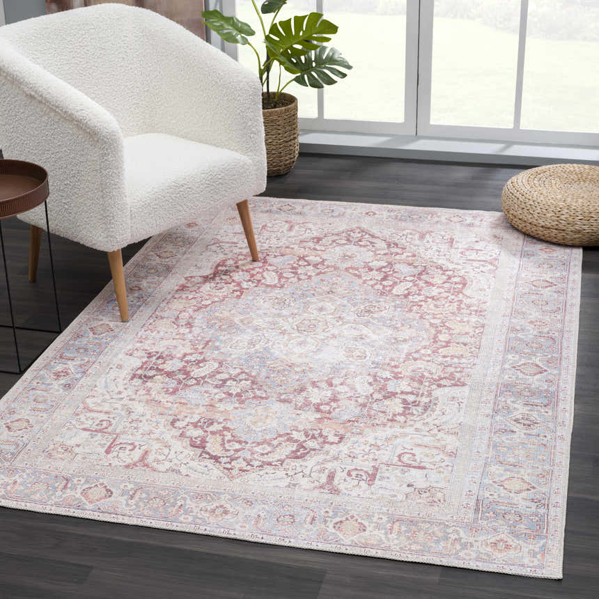 Living room scene with a Cream Rust Leeston Washable Rug, white chair, and woven ottoman. The rug has a vintage, oriental pattern. Roomscene-Rectangle