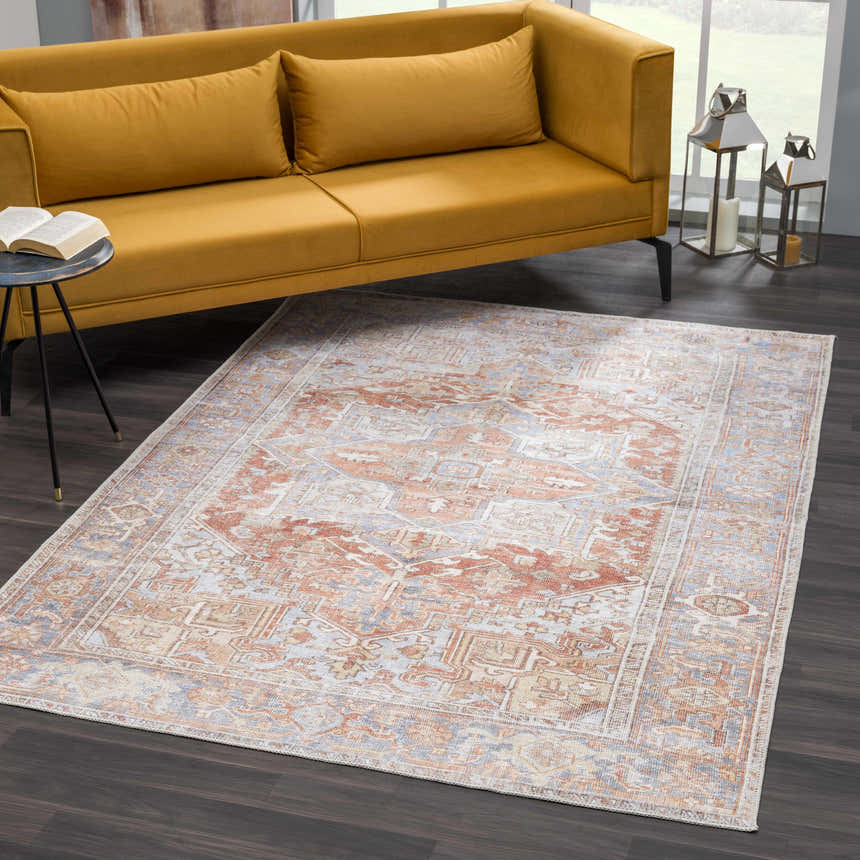 Living room scene with a Rust Maayon Washable Rug, mustard sofa, dark wood floors, and silver lanterns. Roomscene-Rectangle