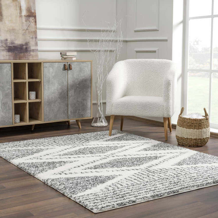 Living room scene with charcoal and cream Trunding Plush Area Rug, white chair, and wood cabinet. Roomscene-Rectangle