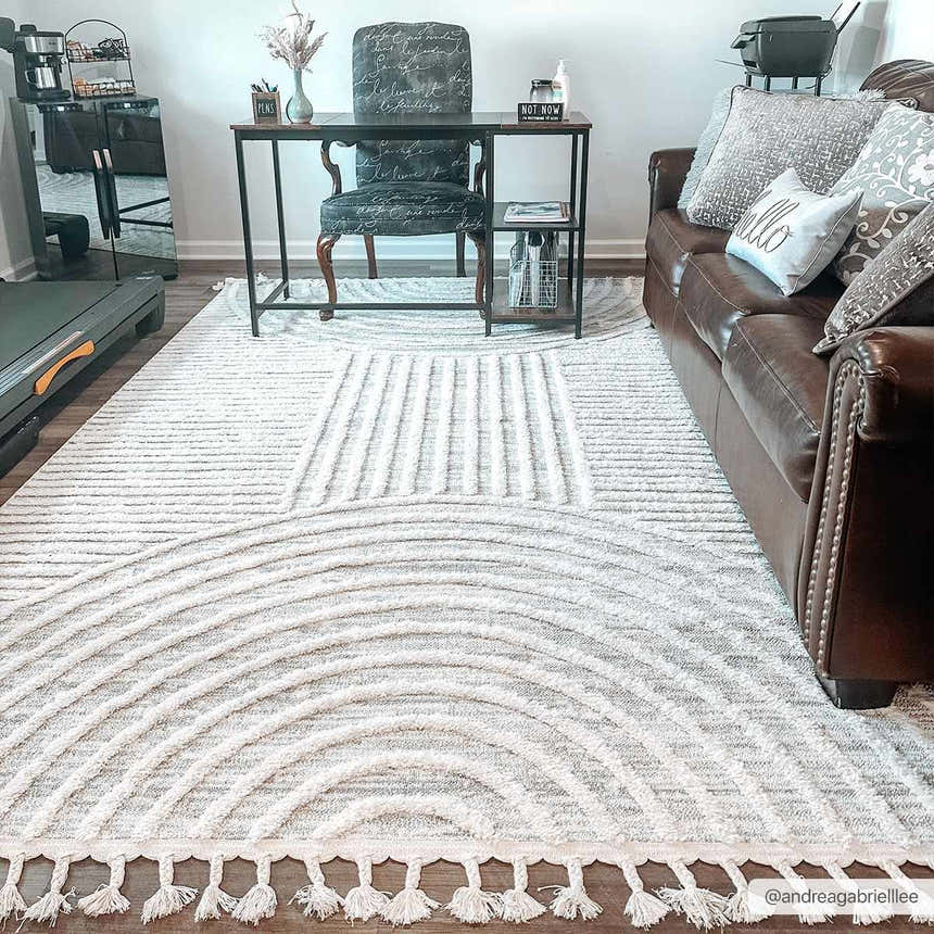 Home office with brown leather sofa and Dauin 3D Rainbow Area Rug. The rug is gray and cream with a geometric design. Roomscene-Rectangle