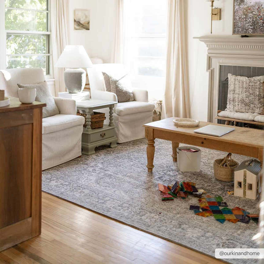 Bright living room scene with a Greenpoint Dusty Blue Washable Rug, white armchairs, and wood coffee table. Roomscene-Rectangle