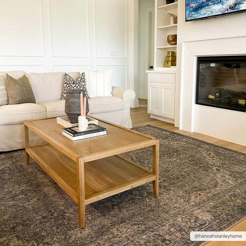 Living room scene with a Greenpoint Dusty Blue Washable Rug under a wood coffee table and cream sofa. Fireplace in background. Roomscene-Rectangle