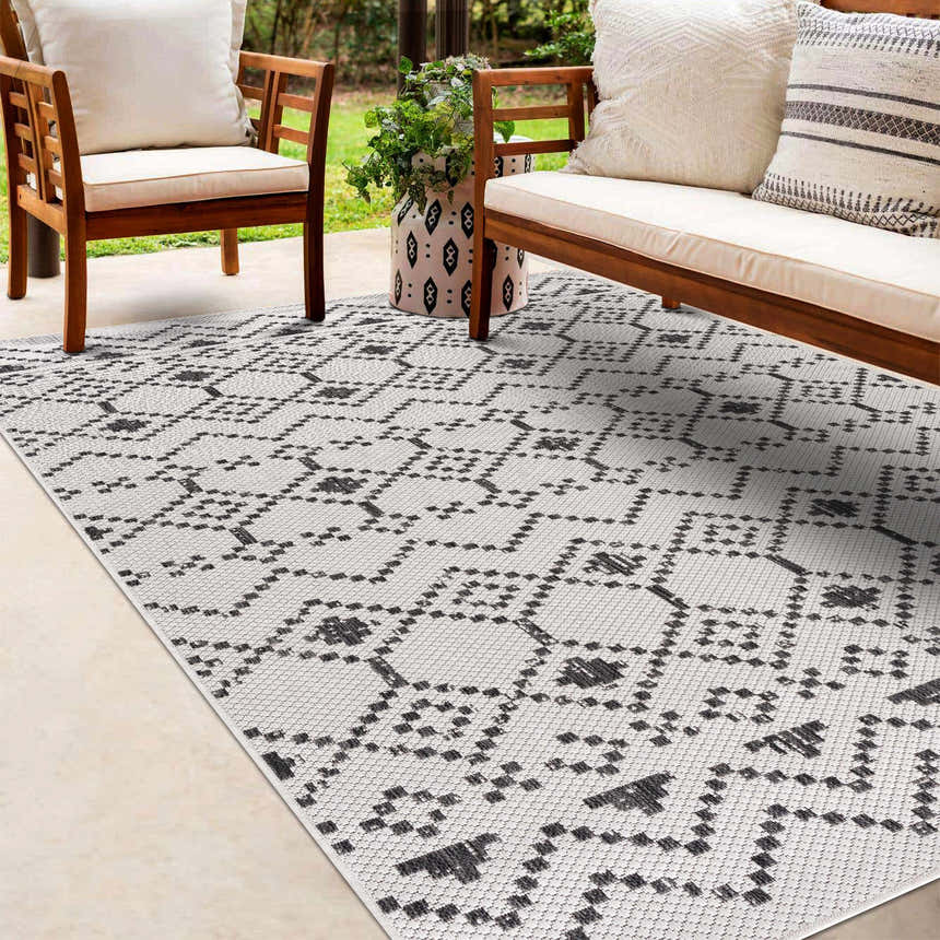Outdoor patio scene with wood furniture and a Haynesville Moroccan Pixel Rug in black and white. Roomscene-Rectangle