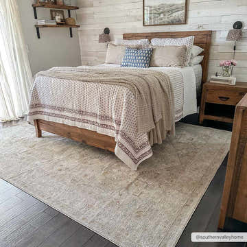 Farmhouse bedroom scene with a wood bed and the amber Engin Thick Luxe Area Rug on dark wood floors. Roomscene-Rectangle