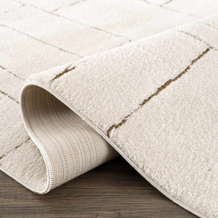 Close up of the beige Keats Area Rug showing geometric pattern and soft texture. Fold