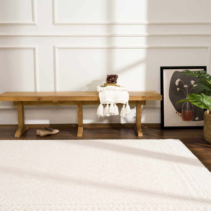 Entryway scene with a light wood bench and the ivory Julio Area Rug. Roomscene-Rectangle