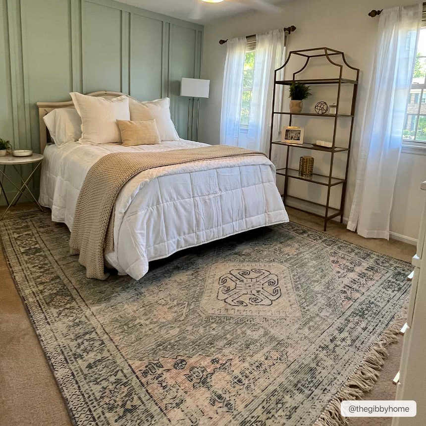 Bedroom scene with a Foraker Sage Green Cotton Rug, white bedding, and sage green paneled wall. Bohemian style. Roomscene-Rectangle