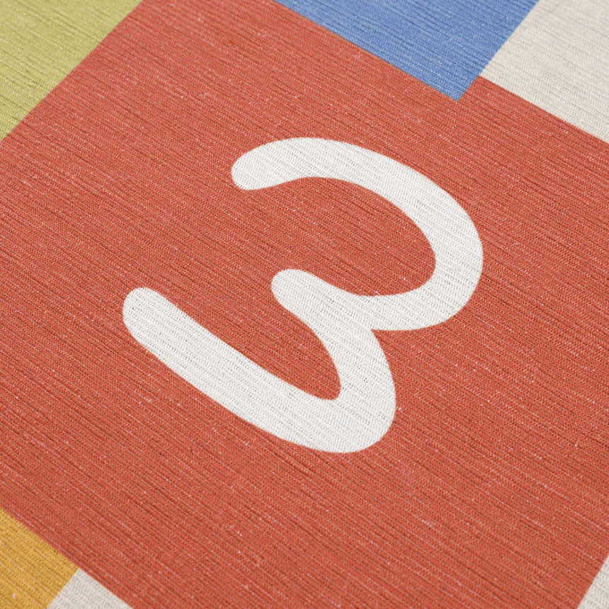 Close-up of a red square with the number 3 on the Lundy Kids Hopscotch rug. Colorful kids rug texture. Texture