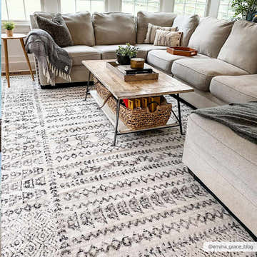 Living room scene with a neutral sectional sofa and the Greig Area Rug in black, gray, and white. Roomscene-Rectangle
