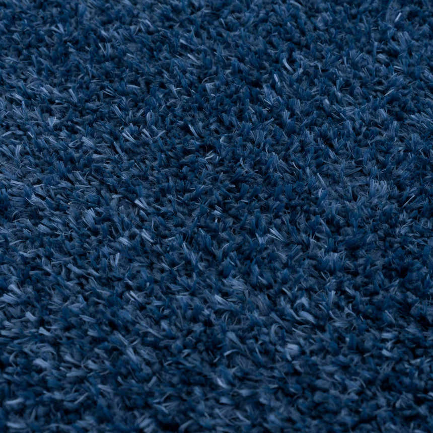 Close-up of the plush texture of the Faina Solid Dark Blue Shag Washable Area Rug, showing its soft, dense fibers. Texture