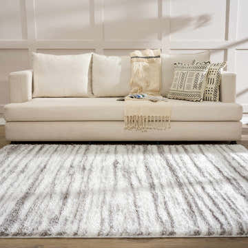 Living room scene with a Natsu Natural Gray Area Rug, off-white sofa, and decorative pillows. Roomscene-Rectangle