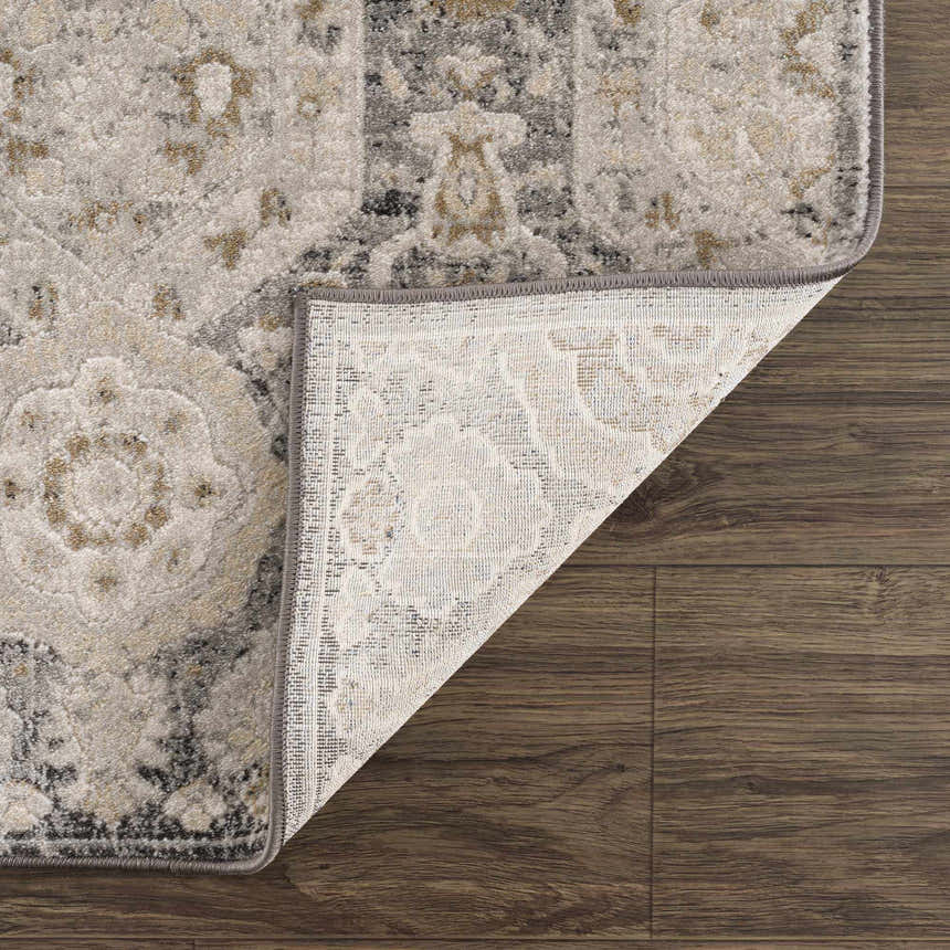 Close-up of the Minoa Area Rug showing its beige, black, and gray bohemian design and machine-woven construction. Fold