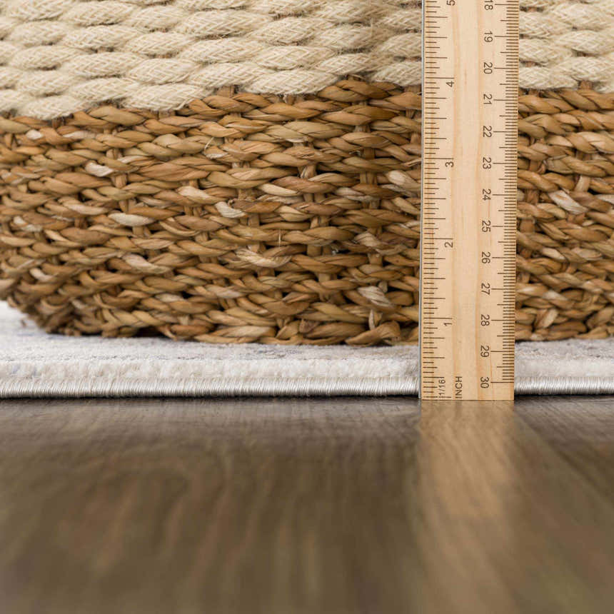 Close-up of the Parkerfield Cream & Blue Area Rug showing the rug's edge, pile height, and texture next to a measuring ruler. Pile