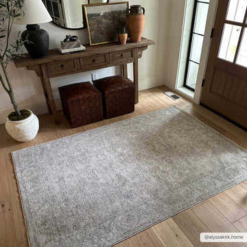 Entryway with wood floors and gray Iikka Thick Luxe Area Rug, console table, and woven leather ottomans. Roomscene-Rectangle