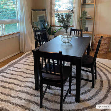 Dining room with a black table and chairs on a shaggy Jola Taupe Area Rug with concentric gray and white stripes. Roomscene-Rectangle