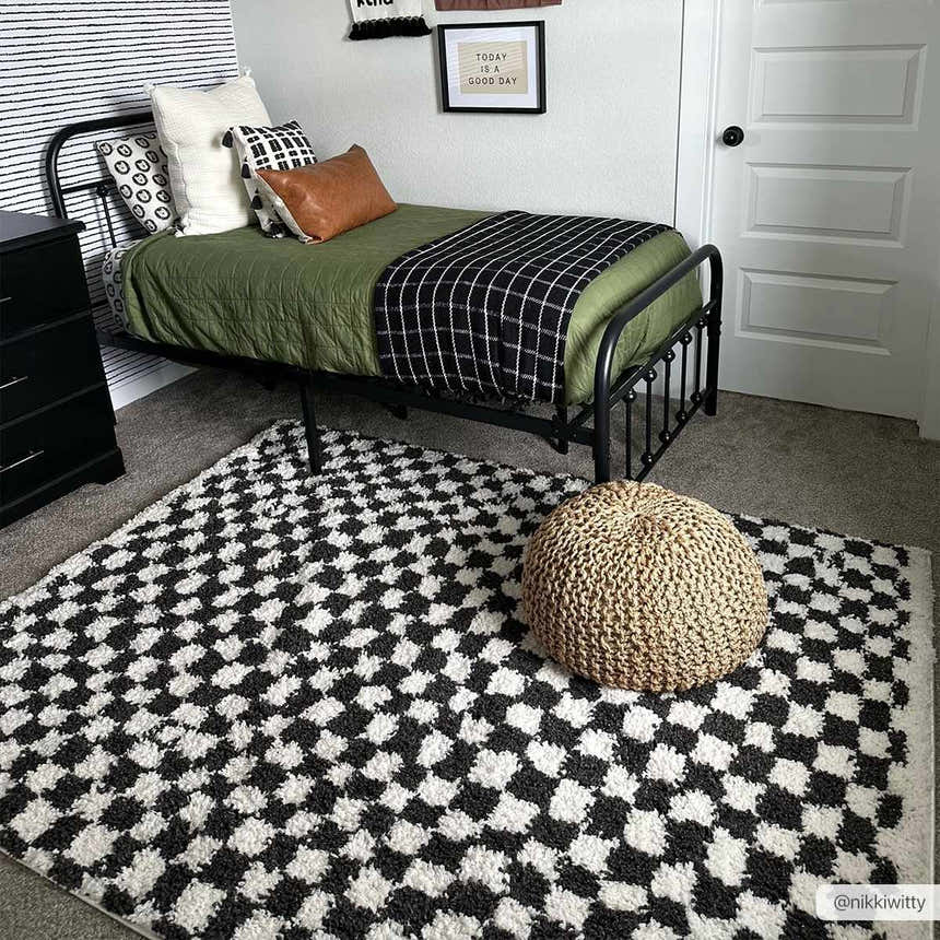 Kids room with a black metal bed and the Kieu Black & White Checkered Shag Rug. Pouf on the rug. Roomscene-Rectangle
