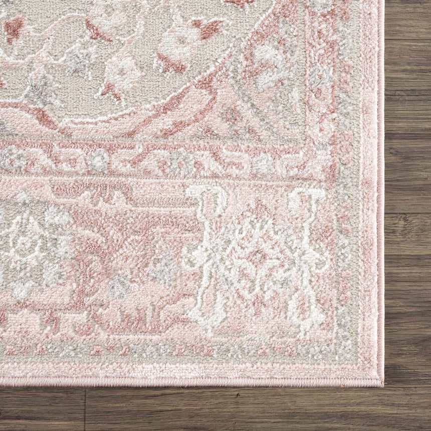 Close-up of the Zora Pink Area Rug showing its traditional vintage pattern in gray and pink on a wood floor. Swatch