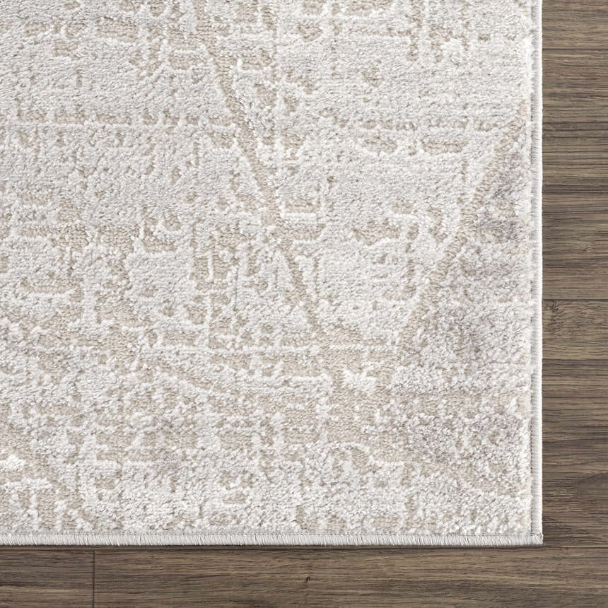 Close-up of the Basia Area Rug featuring a geometric pattern in gray and light gray on a wood floor. Swatch