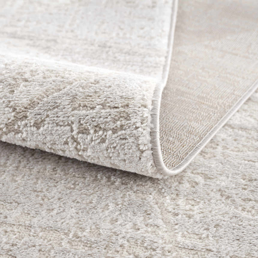Close up of the light gray Basia Area Rug showing texture and backing. Fold