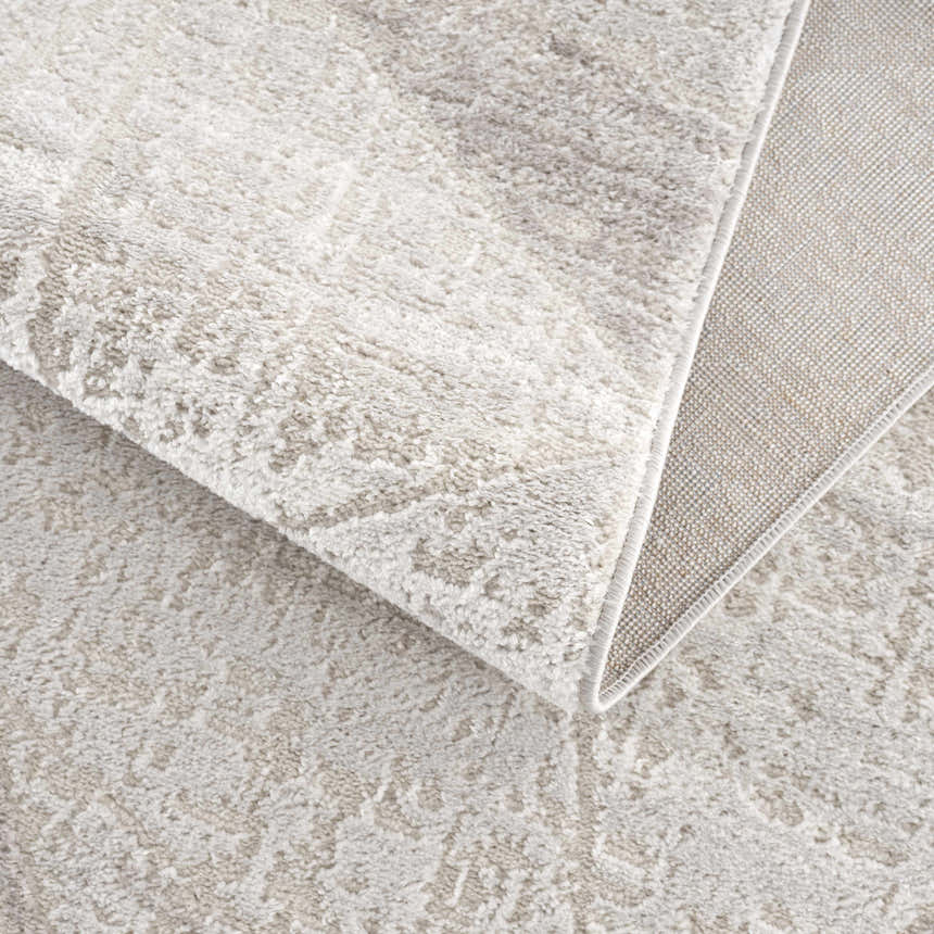 Close-up of the light gray Basia Area Rug showing its geometric pattern and machine-woven texture. Fold