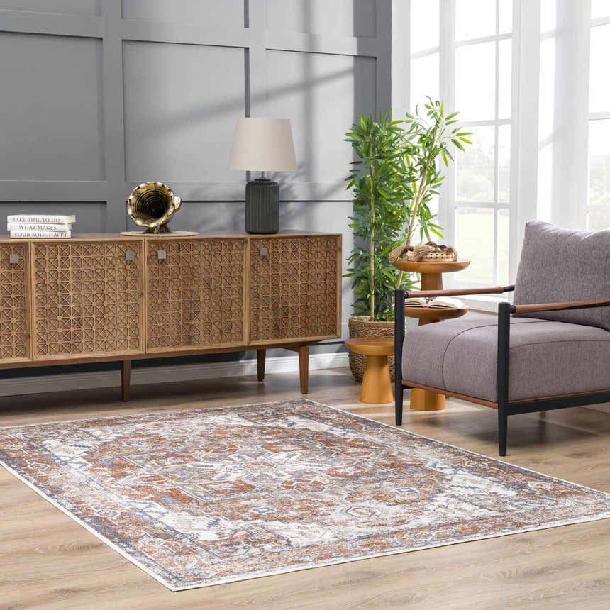 Living room with a Rust Hera Washable Area Rug, gray walls, wood cabinet, gray chair, and natural light. Roomscene-Rectangle