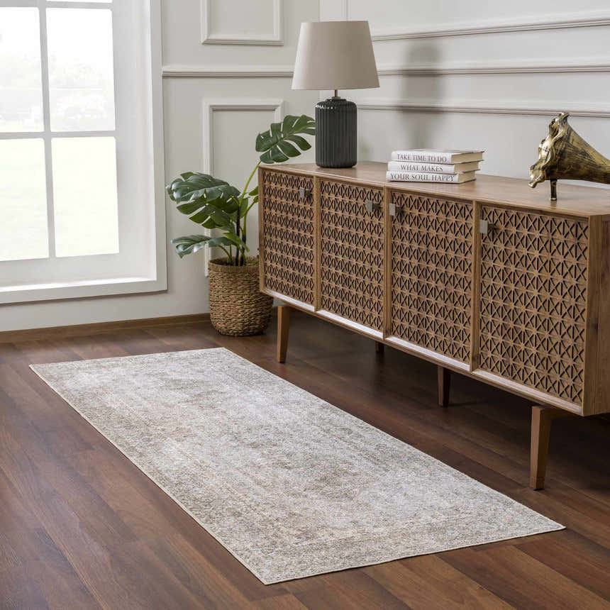 Entryway with wood floors and a tan Gael Boutique Washable Rug. Farmhouse style with a wood cabinet, lamp, and plant. Roomscene-Runner