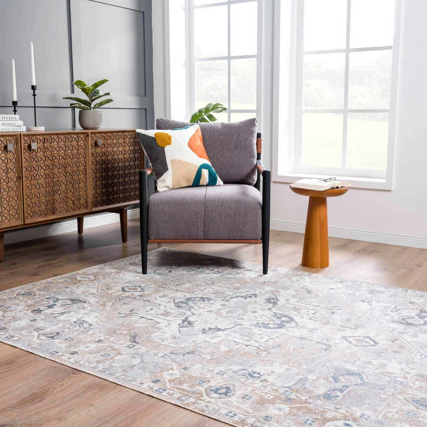Living room scene with a blue, tan, and off white Dobry Boutique Washable Rug, gray chair, and wooden cabinet. Roomscene-Rectangle
