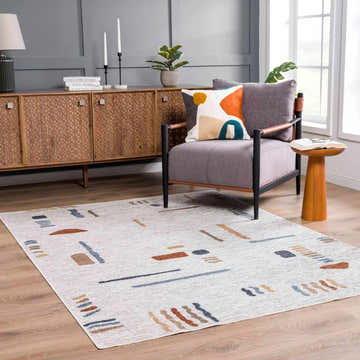 Living room scene with an Arnon Modern Washable Rug in bone with copper, blue, and brown geometric accents. Mid-century modern style. Roomscene-Rectangle
