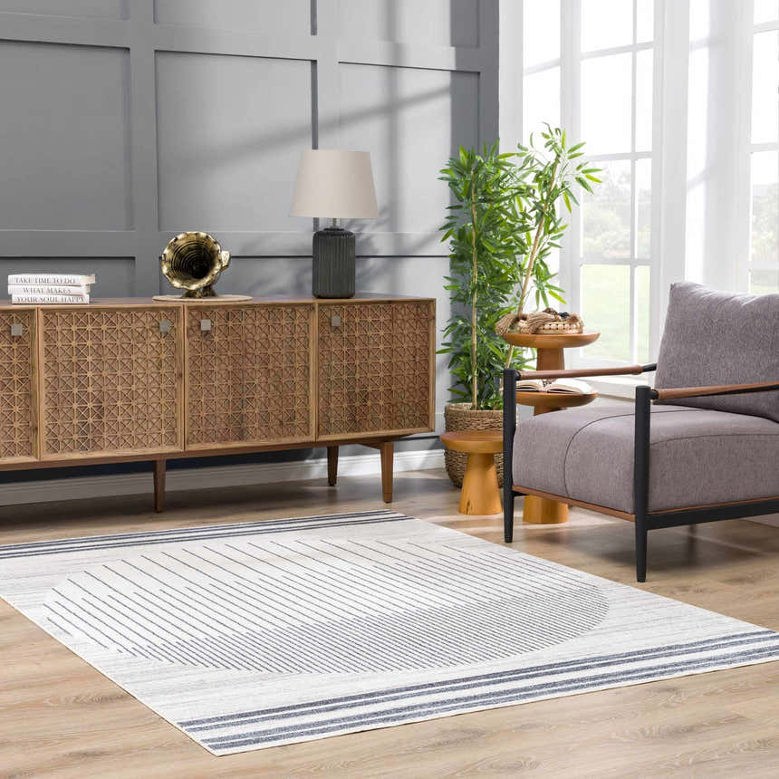 Living room scene with a gray chair and the Thad Medium Gray Washable Area Rug with a geometric design. Roomscene-Rectangle
