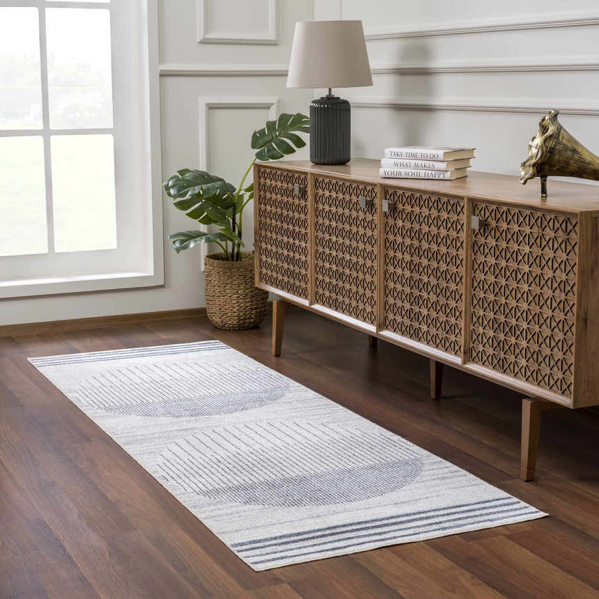 Entryway with geometric Thad Medium Gray Washable Area Rug, wood console table, lamp, and monstera plant. Roomscene-Runner