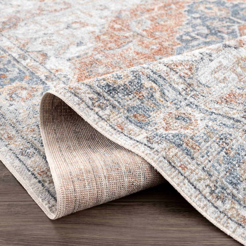 Close up of the Neta Red & Blue rug showing flat pile texture, oriental pattern, and colors: red, blue, gray, and driftwood. Fold