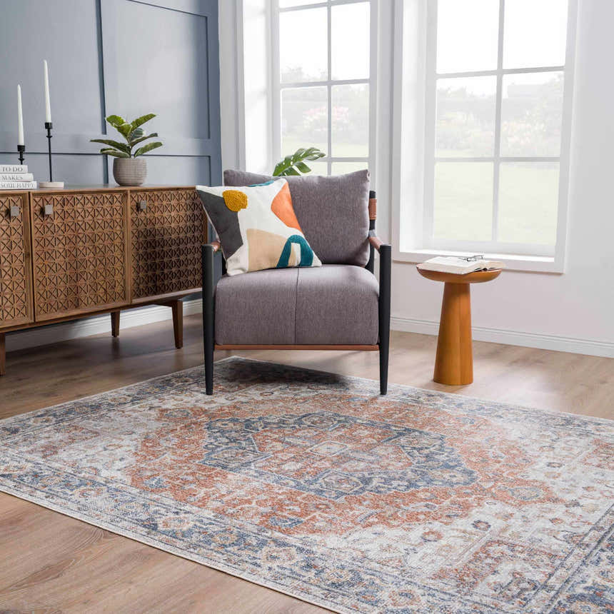 Living room scene with Akram Gray & Orange Washable Area Rug, gray chair, wood cabinet, and natural light. Roomscene-Rectangle