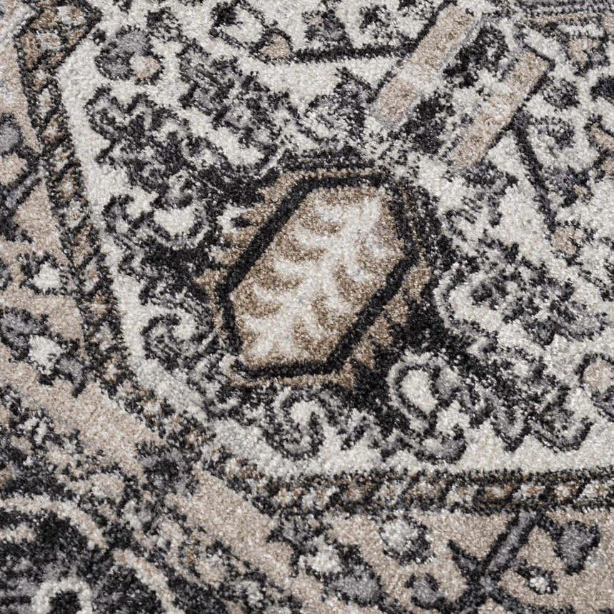 Close-up of the Cabacungan Washable Area Rug. Features a traditional pattern in black, gray, light beige, and taupe. Texture