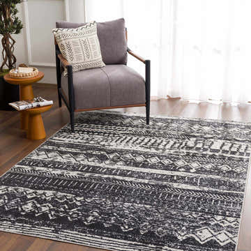 Living room scene with a gray chair on a black and light gray Palali Washable Area Rug. Roomscene-Rectangle