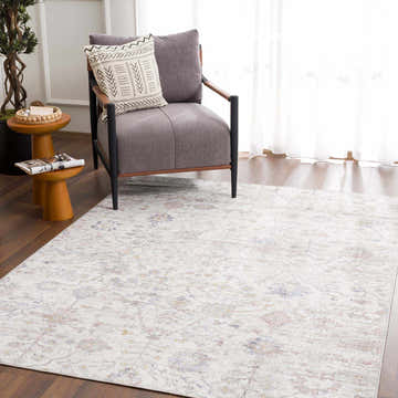 Living room scene with a charcoal chair and the floral Azula Washable Rug in charcoal, cloud gray, dark beige, light gray, and smoke. Roomscene-Rectangle