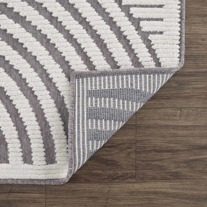 Close-up of the Deron Gray Rainbow Washable Rug showing its geometric pattern, gray and white colors, and machine-woven construction. Fold