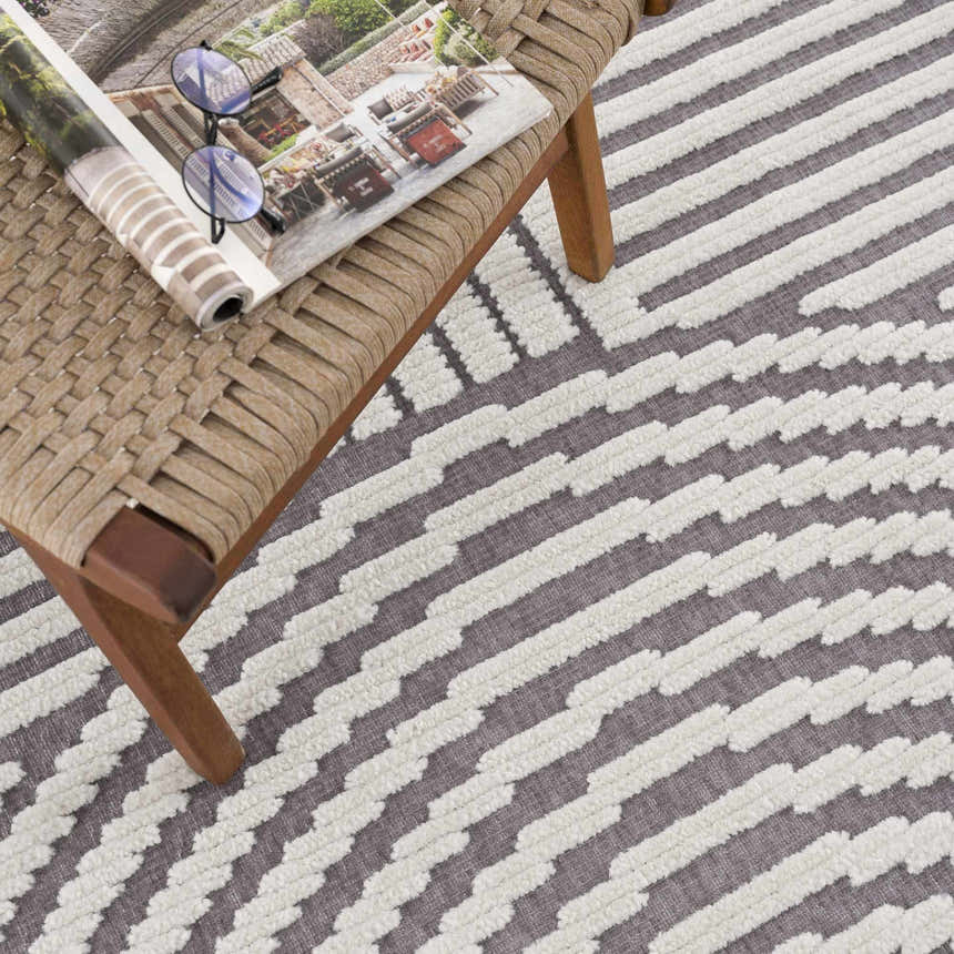 Close-up of the Deron Gray Rainbow Washable Rug showing a geometric stripe pattern in gray and white with a textured, machine-woven design. Styleshot